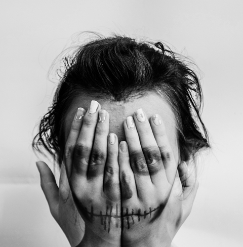 Imagen de una mujer escondiendo su cara